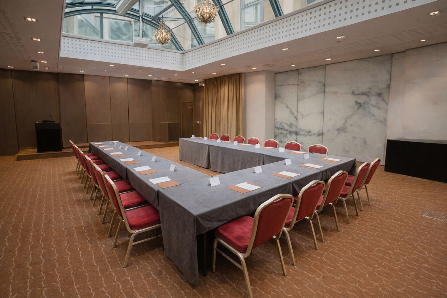 Elegant mötesrum i Stockholm med U-format bord och glastak.