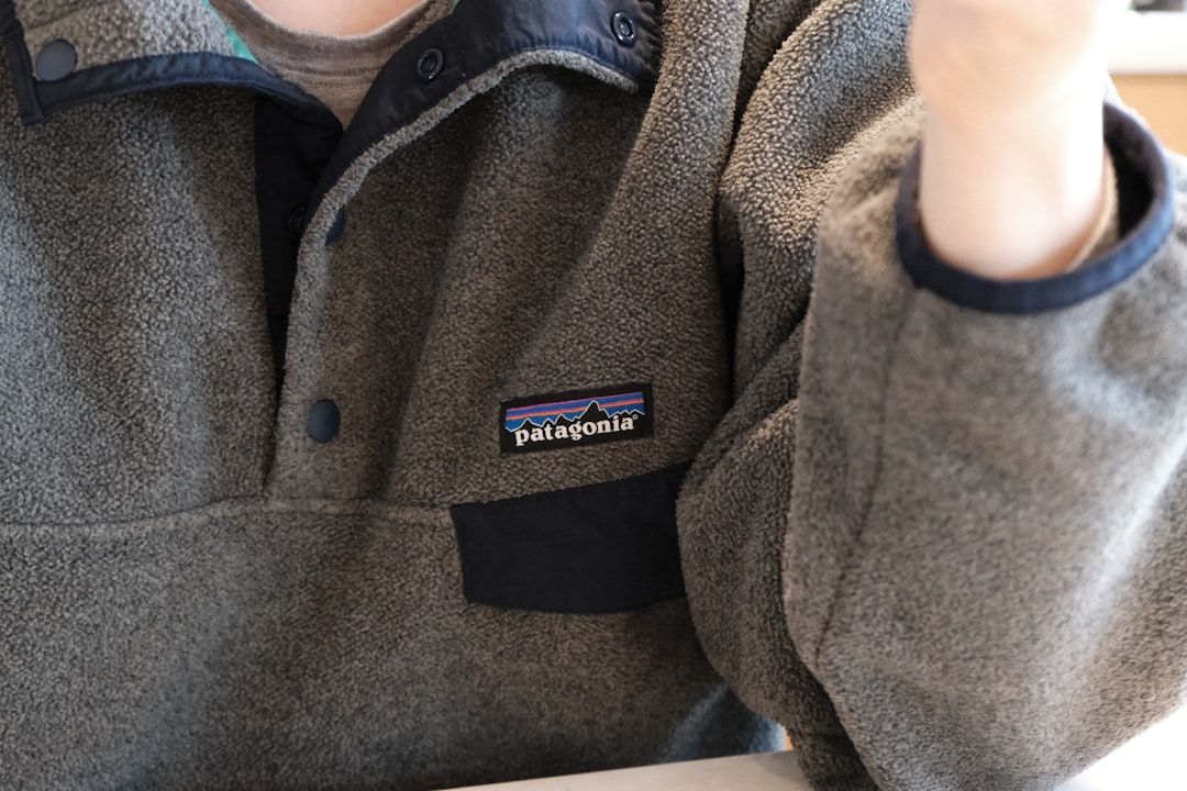 Grå Patagonia fleecetröja med logotyp och tryckknappar.