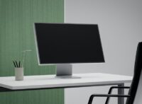 Modern arbetsplats med datorskärm på vitt skrivbord och kontorsstol